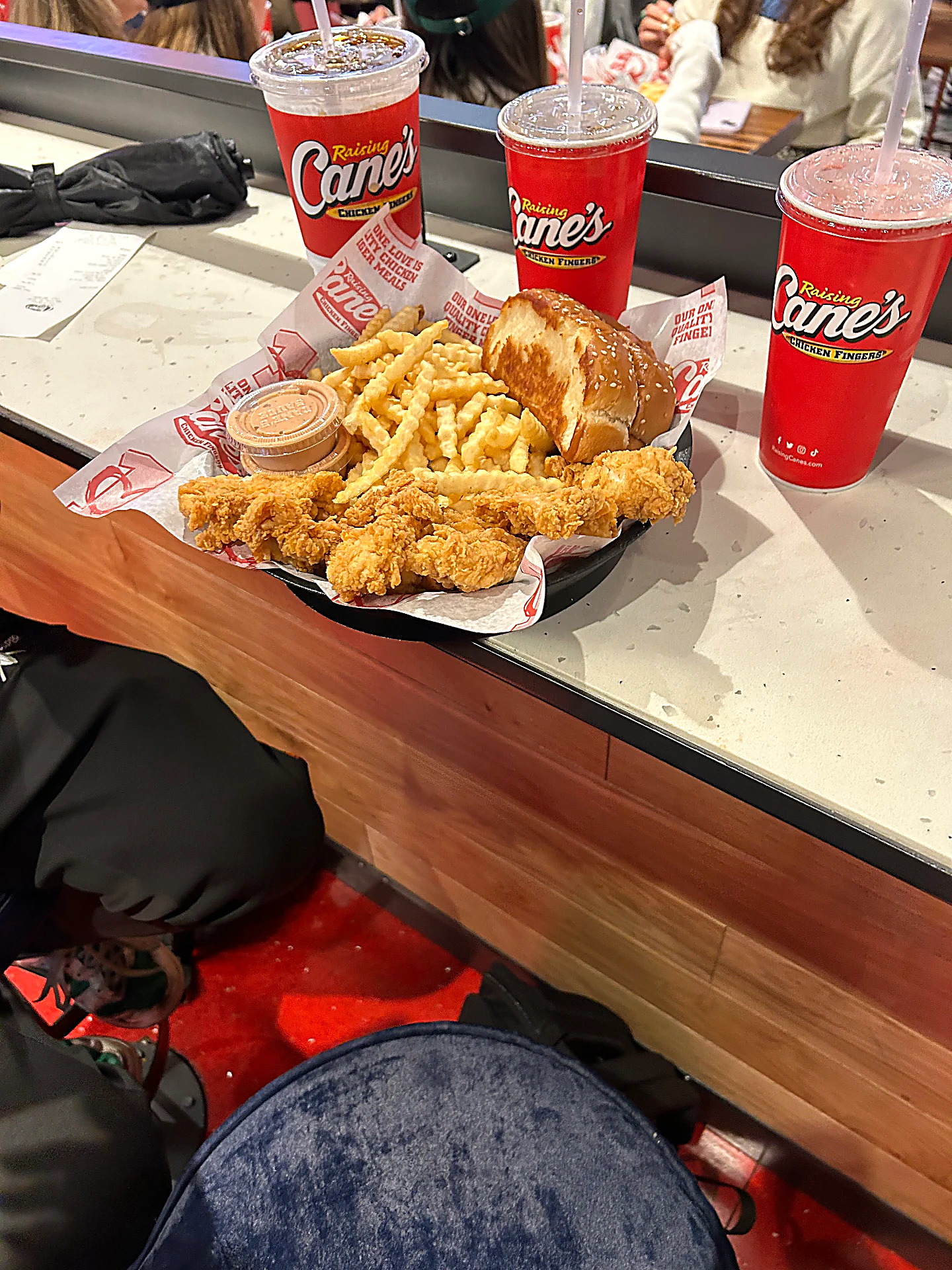 Bak met chicken fingers, fries en drinken bij Raising Cane's