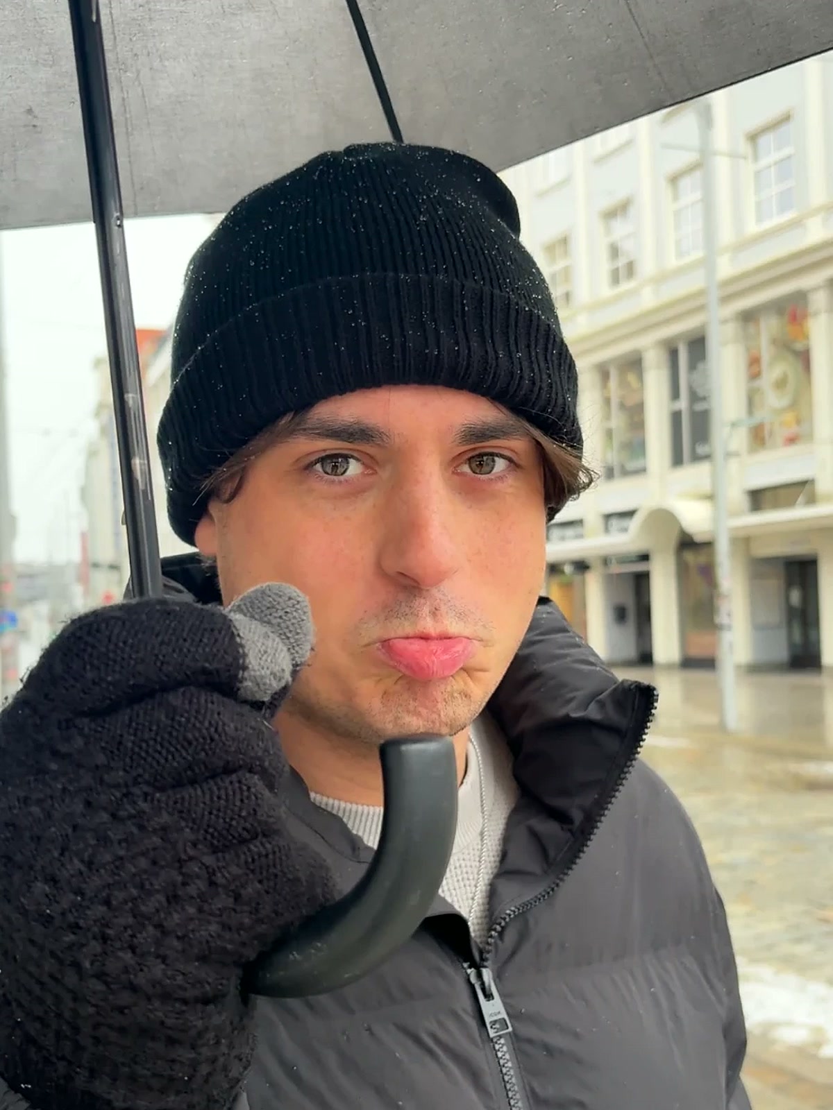 Max onder een paraplu in de regen