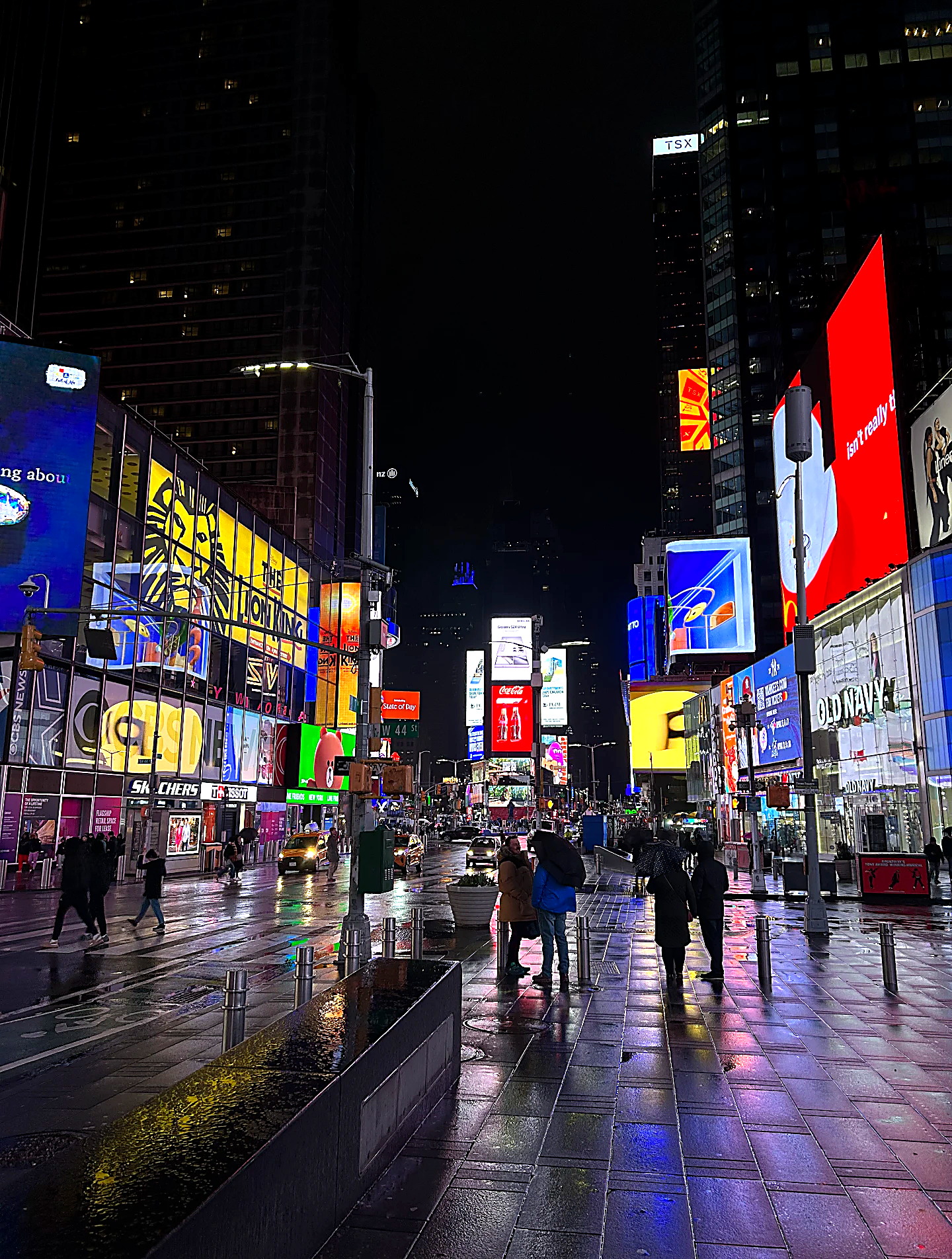 Times Square in de regen bij nacht, vol lichtreclames