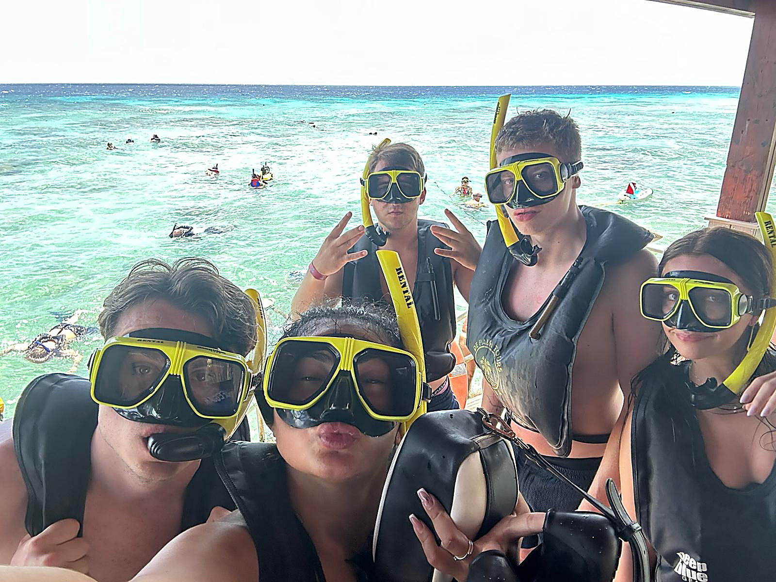 Snorkelselfie met vier vrienden in duikbrillen bij helderblauw water